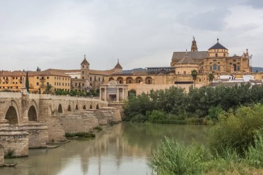 Cordoba İspanya - 09: 13 2021: Guadalquivir nehri üzerindeki Roma Köprüsü, Cordoba Camii-Katedrali, Roma Katolik Piskoposluğu ve Plaza del Triunfo arka planda, Cordoba şehir merkezi, İspanya