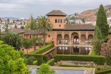Alhambra Granada İspanya - 09 14 2021: Partal Palace veya Palacio del Partal, İspanya 'nın Granada kentindeki Alhambra Kalesi kompleksi içinde yer alan bahçeler ve su gölü etrafında saray manzarası