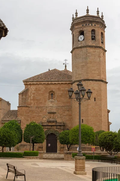 Banos de la Encina Jaen Spain - 09 12 2021: Front facade and tower view at the Iglesia de San Mateo, an iconic gothic and romanesque church located in the center at the Banos de la Encina village