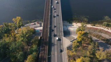 Hava görüntüsü. Köprüde trafik vardı. Güneşli bir günde, arabalar ve kamyonlar küçük bir nehrin üzerindeki beton bir köprüde hareket ediyorlar. Dnepr üzerinde köprü