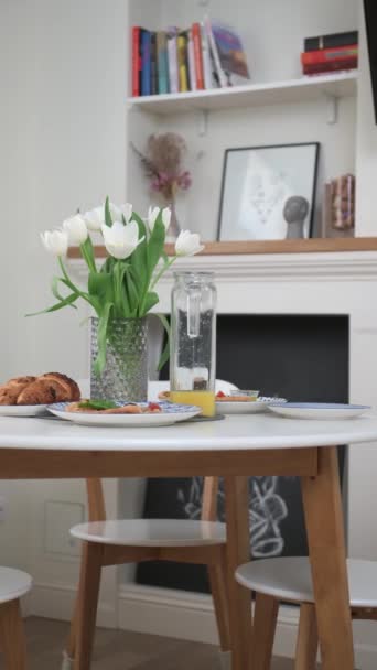 Egy közeli asztal. Reggeli, croissant és fehér tulipán