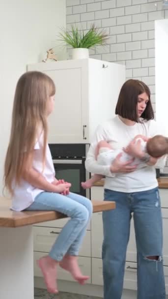 Mamma med små barn i köket — Stockvideo