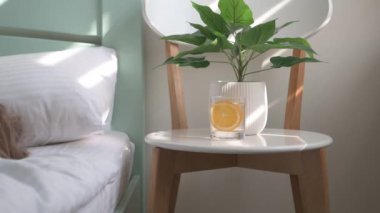 Bardakta limonata yatağın yanındaki sandalyede duruyor, küçük sarışın bir kız yatıyor.