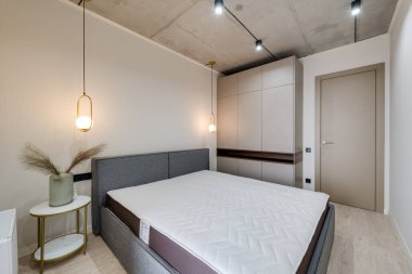 Mobilyalı ve boş yataklı modern bir yatak odası.