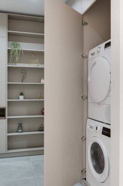Modern bir apartmanın koridorunda çamaşır makinesi olan gardırop.