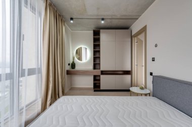 Mobilyalı ve boş yataklı modern bir yatak odası.