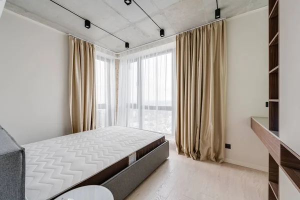 Mobilyalı ve boş yataklı modern bir yatak odası.