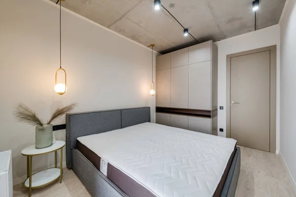 Mobilyalı ve boş yataklı modern bir yatak odası.