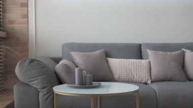 Gri kanepe ve sehpanın penceresi boyunca İskandinav tarzında yumuşak bir hareket.