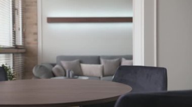Modern bir iç mekânda erkeklerin elleri masanın üzerine çiçekli şık bir vazo konur.