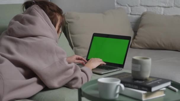 Young Girl Lies Couch Stylish Clothes Types Text Laptop Green — 图库视频影像