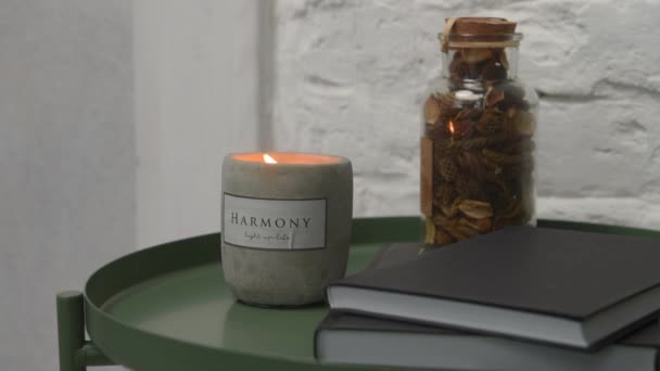 A fading candle stands on a green coffee table in the loft style or scandi — Stock Video