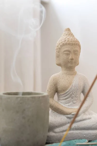 Soothing atmosphere with Buddha statuette and smoking candle — Stock Photo, Image