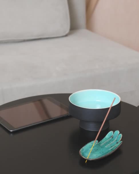 Скользя вдоль кофейного столика с планшетным декором и благовониями — стоковое видео
