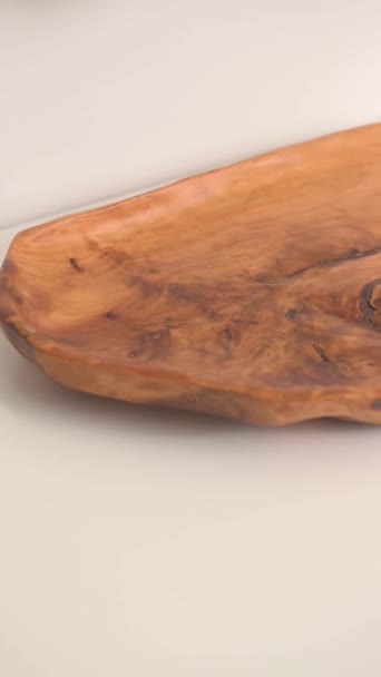 Bruin mooi houten bord met patroon en droge bloem op een witte achtergrond close-up — Stockvideo