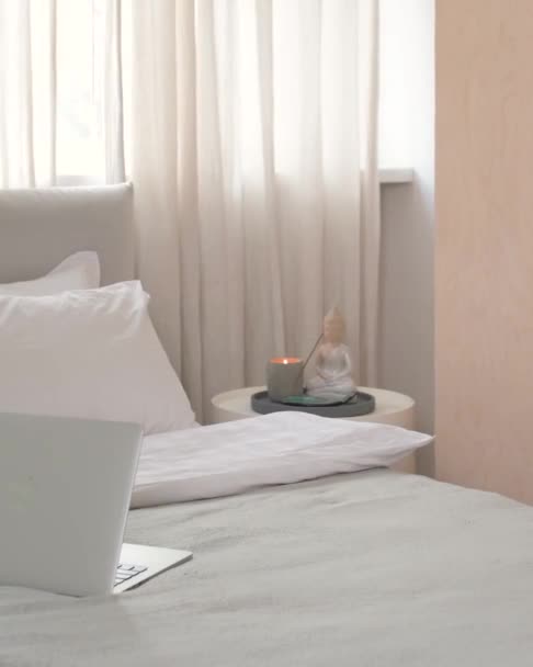 Zbliżenie rogu łóżka z laptopem i stół ze świecami i Budda — Wideo stockowe