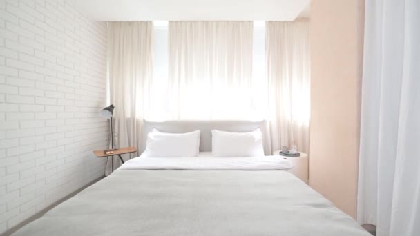 Brede kijkhoek op een lichte kamer met een bed en een groot raam — Stockvideo