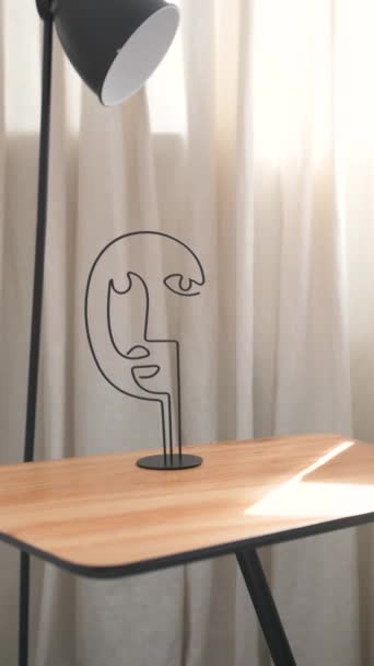 Meja kopi dengan buku dan gambar abstrak kepala menghadap latar belakang dinding bata putih — Stok Video