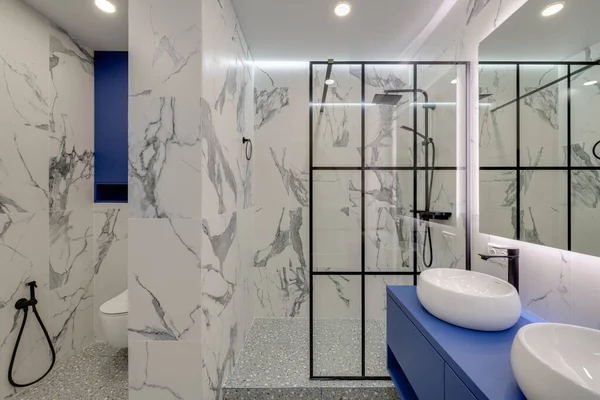 Lavaboları olan modern, parlak bir banyo ve alt başlıklı büyük bir ayna. Yüksek kalite fotoğraf
