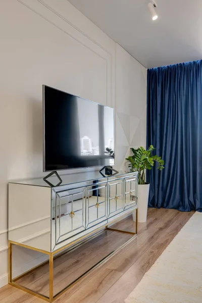 Porta TV a specchio all'interno con tenda blu e pareti luminose — Foto Stock