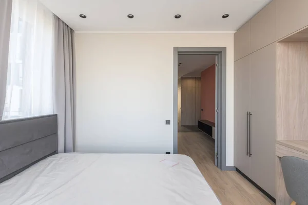 Utsikt över utgången från det tomma rummet med stora säng och taklampor — Stockfoto