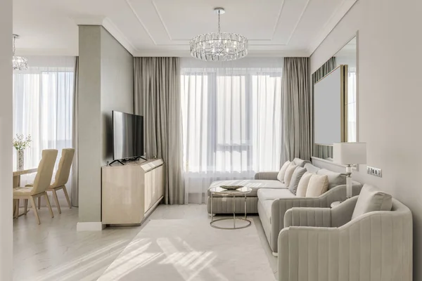 Classic interior design large bright room in neutral colors with furniture and chandelier