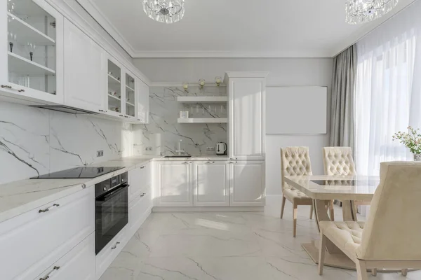 Bright, grey modern kitchen with appliances and dining table by the window. Sunlight. High quality photo