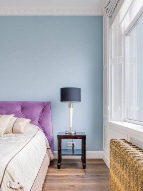 Geniş bir pencerenin altında, parlak ferah bir odanın yakın çekiminde altın retro ısıtıcı. Yüksek kalite fotoğraf