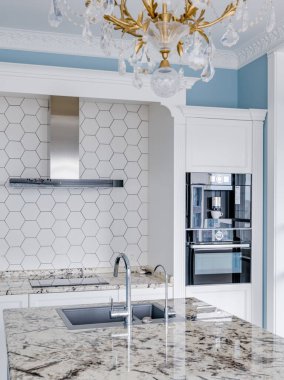 Mavi duvarları ve mermer masası olan modern, parlak bir mutfak. Yüksek kalite fotoğraf