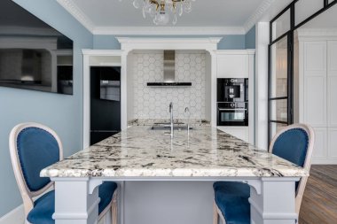 Mavi duvarları ve mermer masası olan modern, parlak bir mutfak. Yüksek kalite fotoğraf