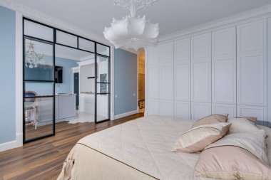 Büyük, parlak, mavi duvarlı bir oda, büyük beyaz bir avize ve cam bir duvar. Yüksek kalite fotoğraf