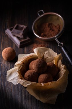 Kahverengi arka planda kakao tozlu lezzetli siyah çikolatalı trüf.