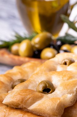 Ön planda zeytinli, arka planda zeytinli ve zeytinli leziz Ceneviz Focaccia..
