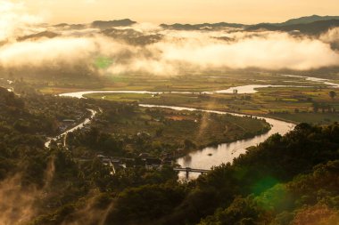 Güneş doğarken Kok Nehri 'nin havadan görünüşü, vadideki ve dağlardaki pirinç tarlalarını sis kaplıyor. Nehir Myanmar 'dan geliyor. Mekong Nehri 'ne akar. Chiang Mai, Tayland.