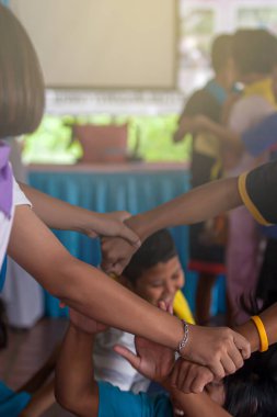 Okul gezileri sırasında çeşitli çocukların el ele tutuşmalarının yakın çekimi. Birlik, takım çalışması, ilişki kavramları. Hareket bulanıklığı.