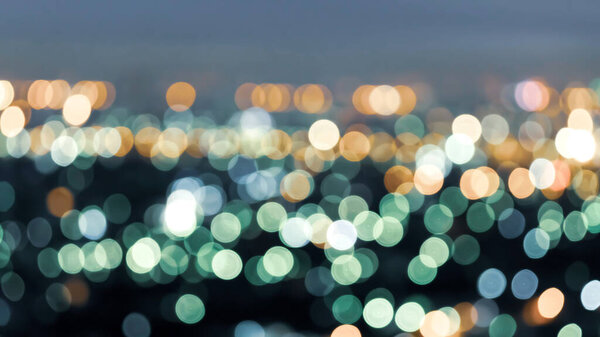 High angle view, defocus cityscape at twilight, bright and colorful blurred background with bokeh circle round lights, abstract bokeh creative background. Night city life concept.