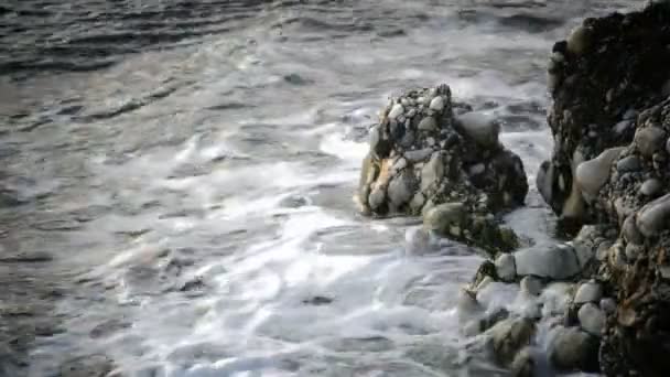 Wellen Meer gegen den Felsen bei Sonnenuntergang. — Stockvideo