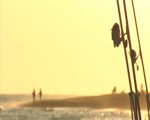 Εξέλικτρα αλιείας στο ηλιοβασίλεμα. Surf casting. — Αρχείο Βίντεο