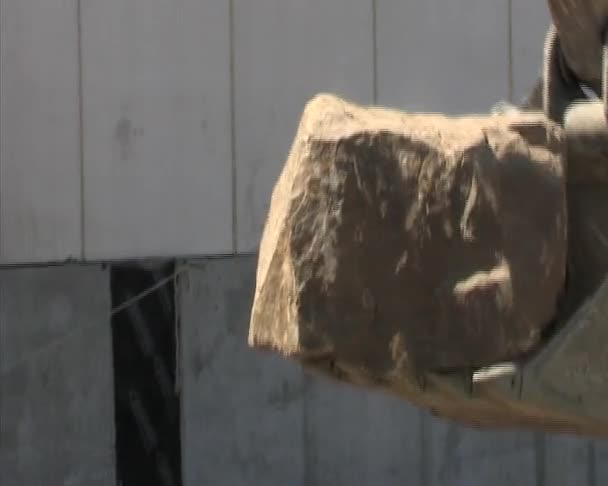 Backhoe ou escavadeira colocando grande pedra em uma trincheira. Construção . — Vídeo de Stock