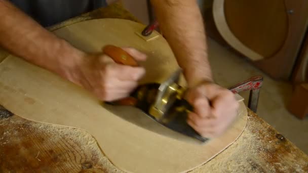 Tesař, řemeslník nebo houslař, dávat dřevěný hoblík na flamenco kytaru. — Stock video