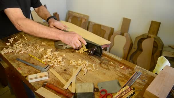 Luthier dando plaina de madeira no local de trabalho . — Vídeo de Stock