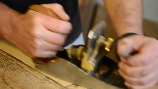 Luthier trabajando en el lugar de trabajo con una cepilladora de madera . — Vídeo de stock