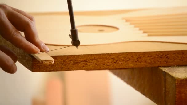 Luthier corta madera con sierra, guitarra flamenca — Vídeo de stock