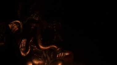 Ganesha, Hindu tanrısı figürü, mum ışığıyla aydınlatılmış.