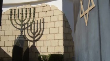 Büyük Menorah ve David Star Yahudi mezarlığının girişinde, eğil.