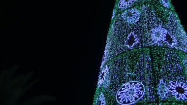 Yapay bir Noel ağacında ışıklar yanıyor.