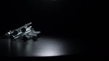 Siyah arka planda dönen sanayi vidaları dağı