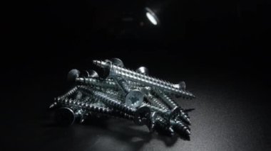 Siyah arkaplanda dönen metal vidalar