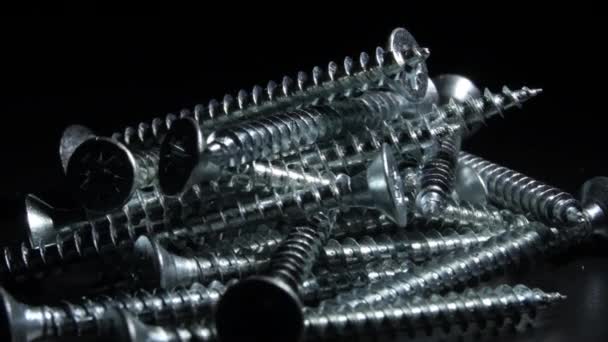 黑色底座上旋转的金属螺丝堆积如山 — 图库视频影像
