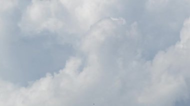 Hızla ilerleyen bulutlar mavi gökyüzünde hareket ederek atmosfer yaratıyor.